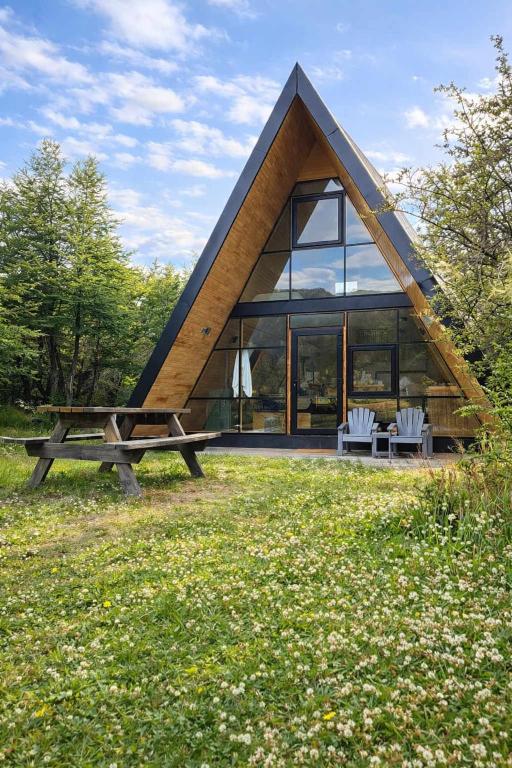 a house with a triangular roof and a picnic table at OUTSCAPE I Estero I Wifi I Escalada I Cerro Castillo in Villa Cerro Castillo