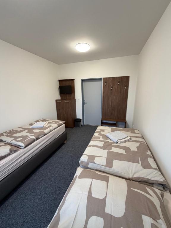 a room with two beds in a room at Penzion BETA in Třebíč
