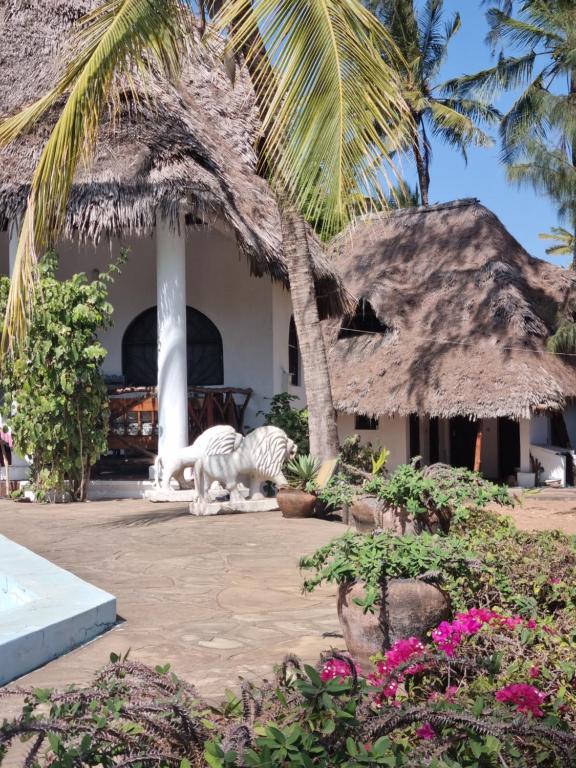 a zebra standing in front of a house at Sofia House - Beach Paradise with Kite, Dive and more in Watamu