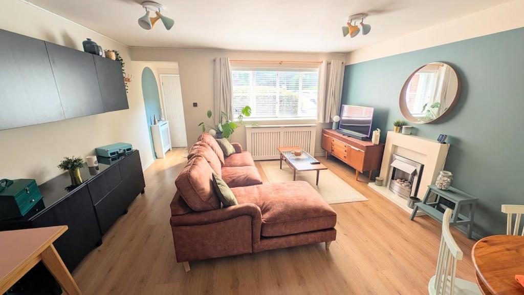 a living room with a couch and a fireplace at 70's Inspired 1 Bed flat in Knebworth