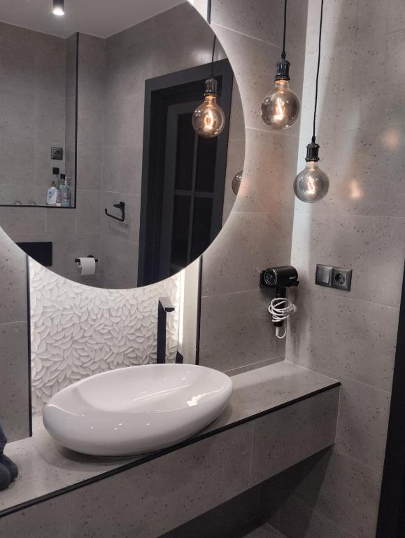 a bathroom with a white sink and a mirror at Balka-centr Tiraspol in Tiraspol
