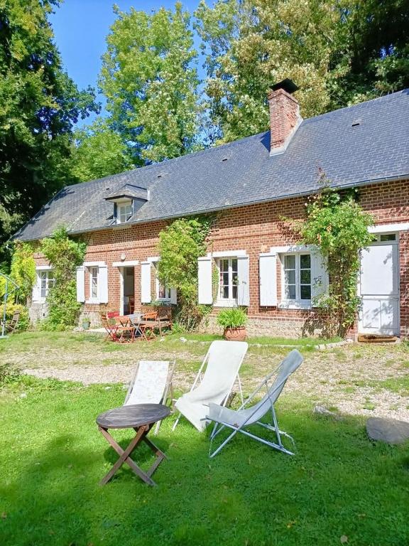 two chairs and a table in front of a house at Gîte rural de Criquemanville - Maison familial 4 chambre avec grand jardin in Sassetot-le-Mauconduit