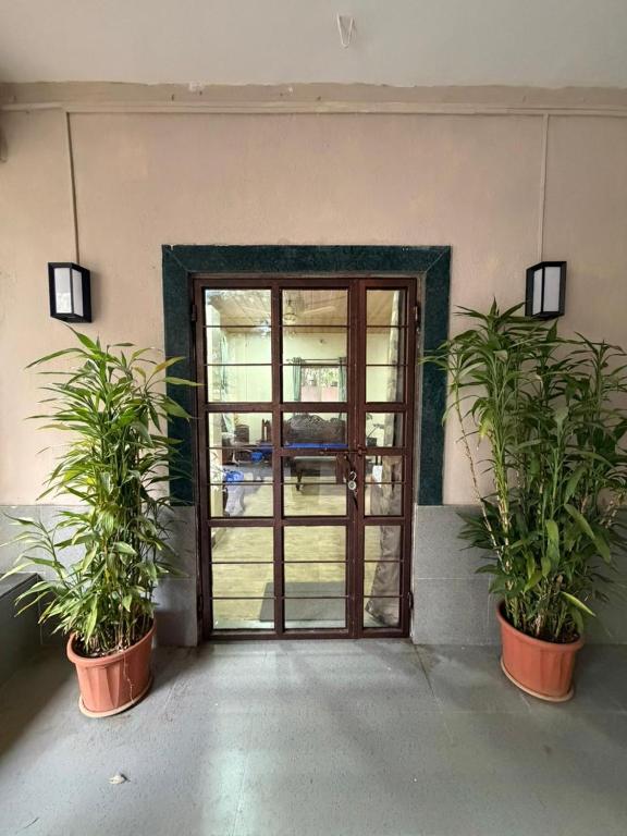 two potted plants in front of a door at Umang Homestay in Talegaon Dābhāde