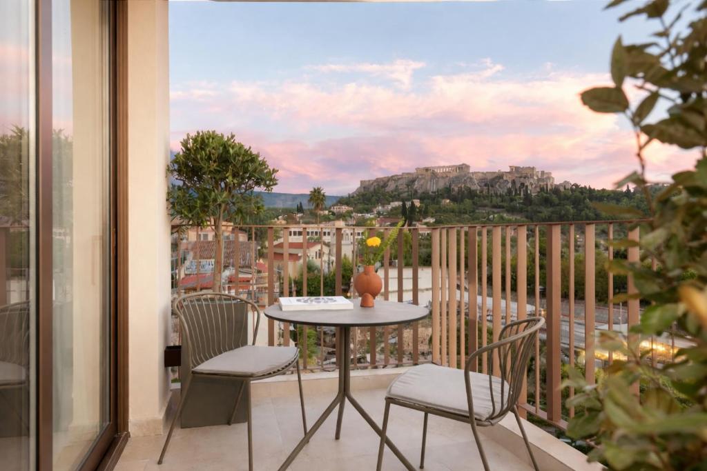 a table and chairs on a balcony with a view at Altar Suites in Athens