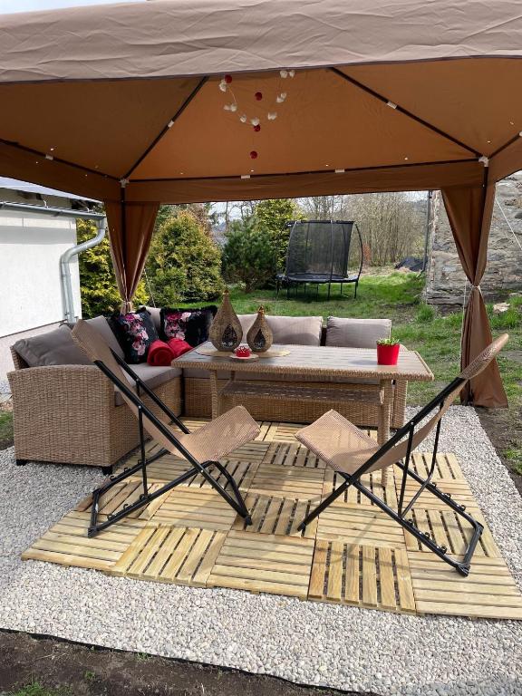 a tent with a couch and a table under it at Zlatá Chalupa Heřmanovice in Heřmanovice
