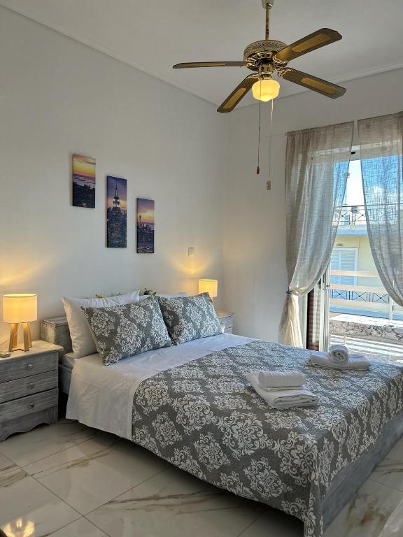 a bedroom with a bed and a ceiling fan at Sunny Beachfront Apartment in Nerántza