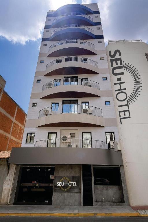 a tall building with a sign on the side of it at Seu Hotel in Patos
