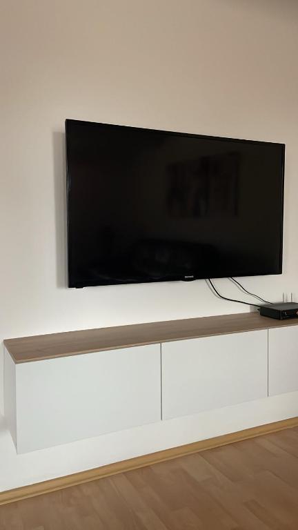 una TV a schermo piatto posizionata su un mobiletto bianco di BT Lux apartment 2 a Skopje