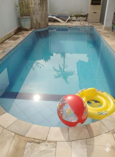 a swimming pool with a yellow and red ball in it at casa azul in Itanhaém