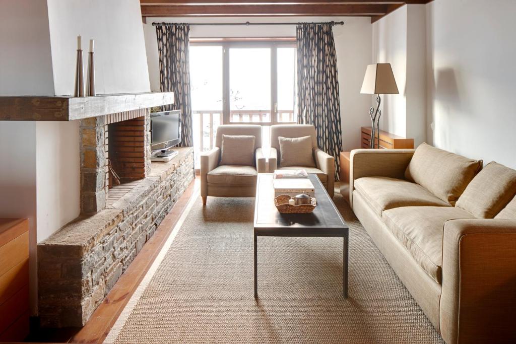 sala de estar con sofá y chimenea en Pleta de Nheu 2 by FeelFree Rentals, en Baqueira Beret