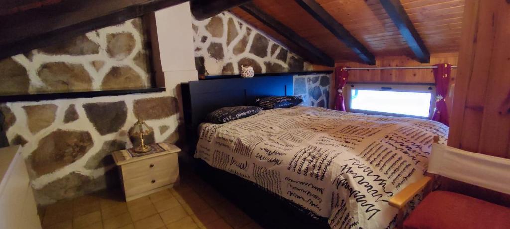 a bedroom with a bed in a stone wall at Il Nido Nel Bosco in Motta