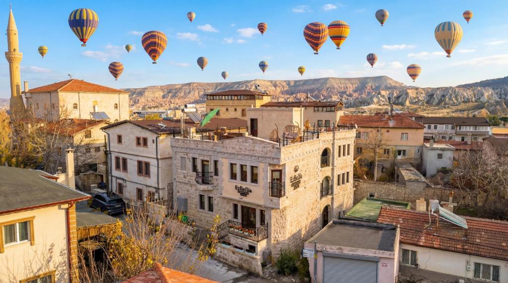 a group of hot air balloons flying over a city at Erbelya Cappadocia House in Göreme