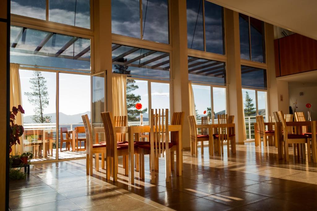 a dining room with a table and chairs and windows at Hostería Huinganco in Huinganco