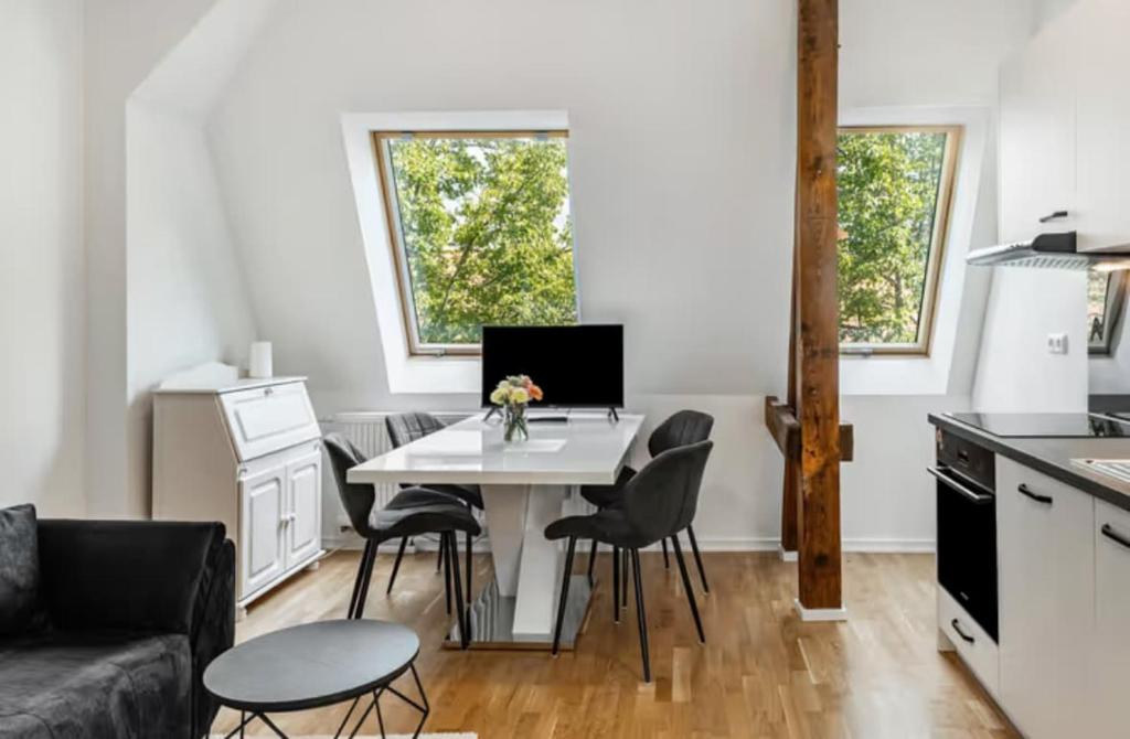 a kitchen and living room with a white table and chairs at Elb Park Suite in Wittenberge