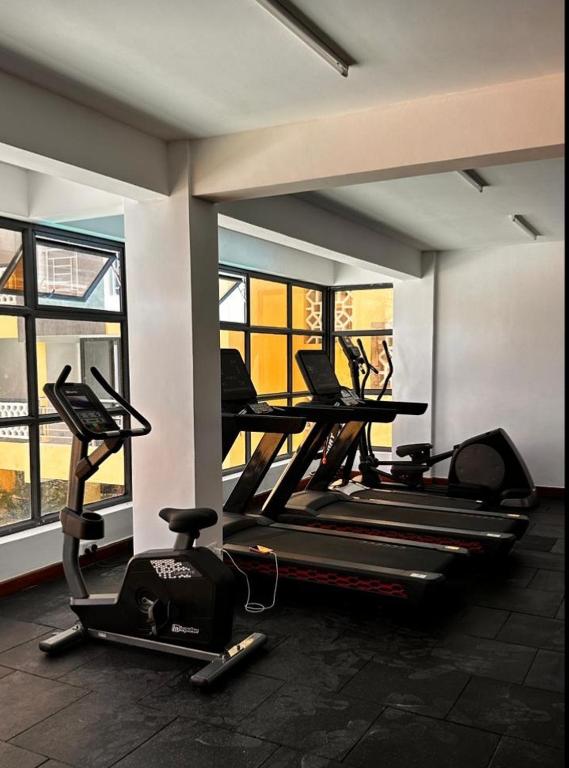 a gym with two treadmills and two exercise bikes at CAROL homes in Mombasa