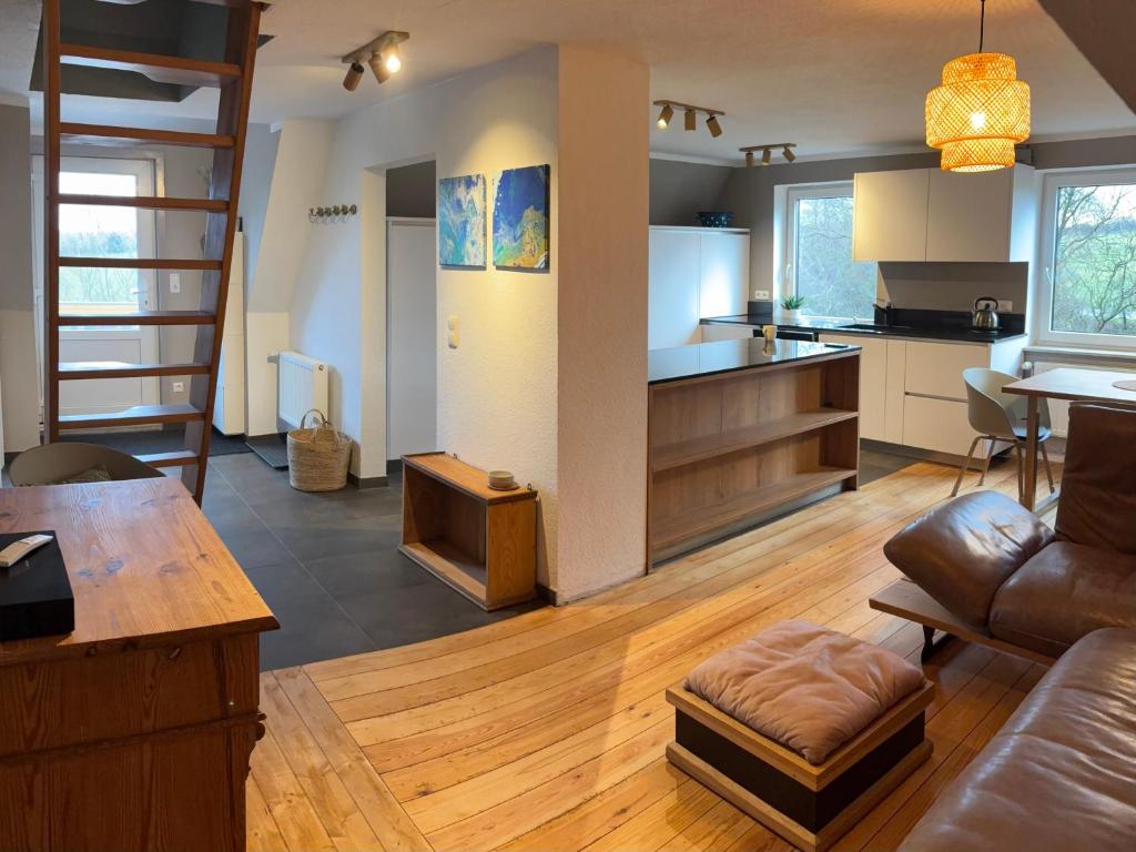 a kitchen and living room with a couch and a table at Schwalbennest Flensburger Förde in Westerholz