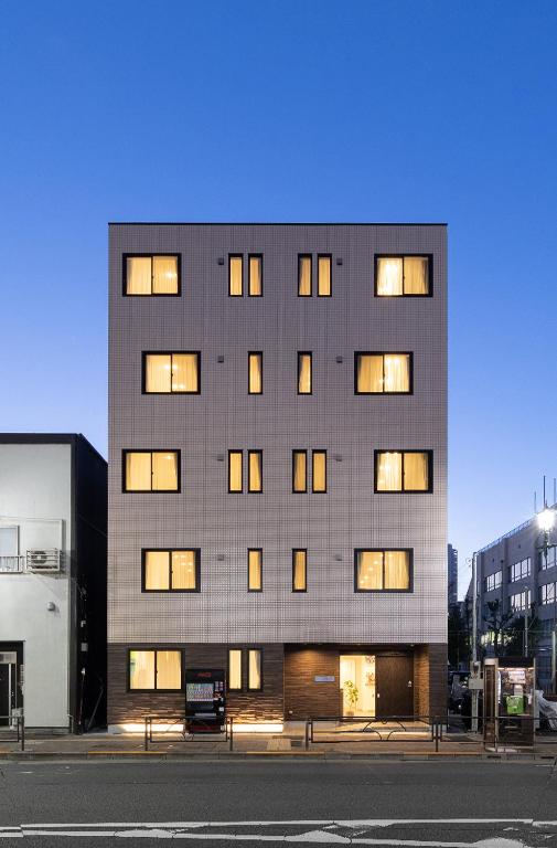 a tall building with many windows on a street at Hotel Kototoi East in Tokyo