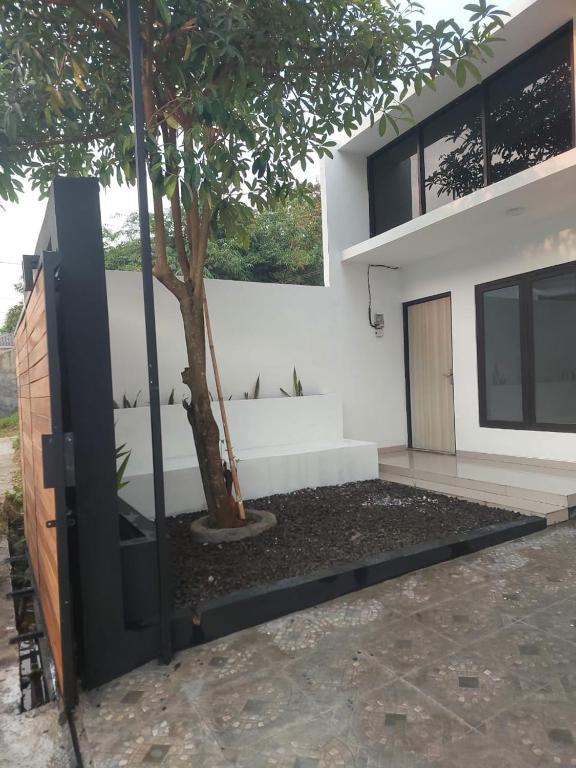 a house with a tree in front of it at Adah 786 Villa Syariah in Krian
