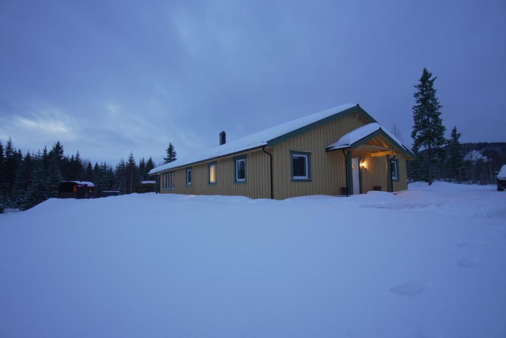 a house in the snow with a light on it at General House in Namsskogan