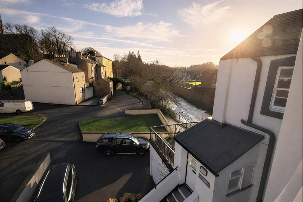 a car parked in a parking lot next to a house at Dog Friendly Lakeland Apartment - Private Parking - Central Location in Cockermouth