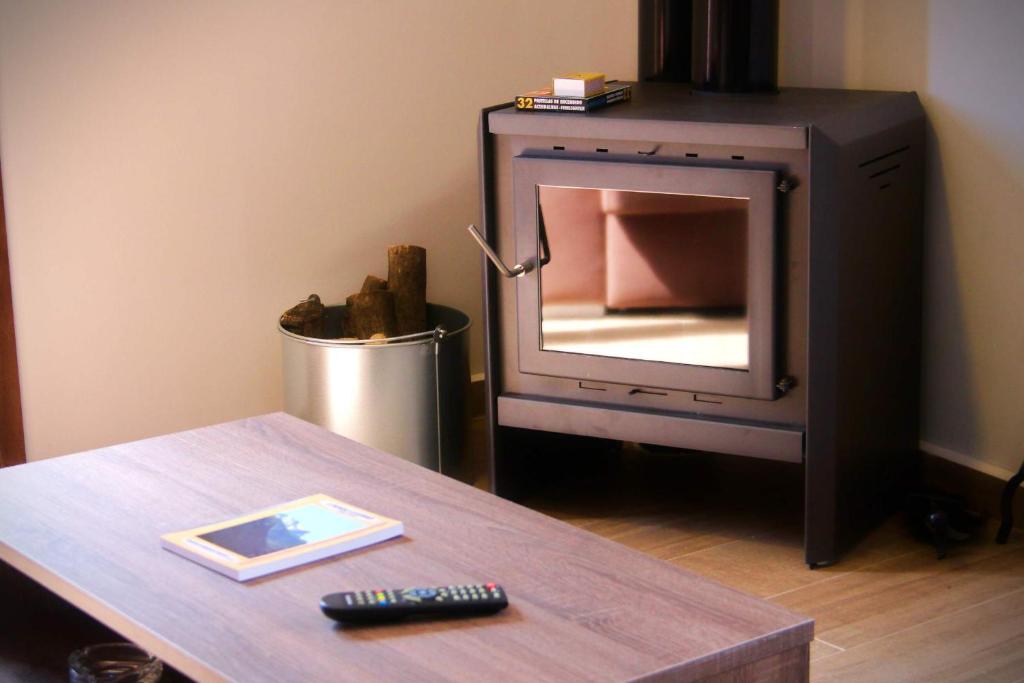a tv with a mirror on a table with a remote control at Apartamentos Aldeas de Pontones in Pontones