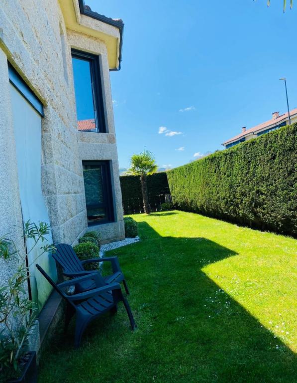 a yard with a bench and a hedge at La Villa Allariz in Allariz