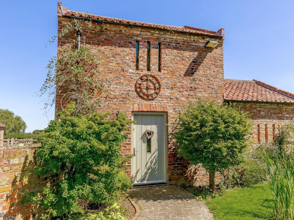 a brick building with a door with a clock on it at 2 Bed in York oc-g0154 in Ellerton