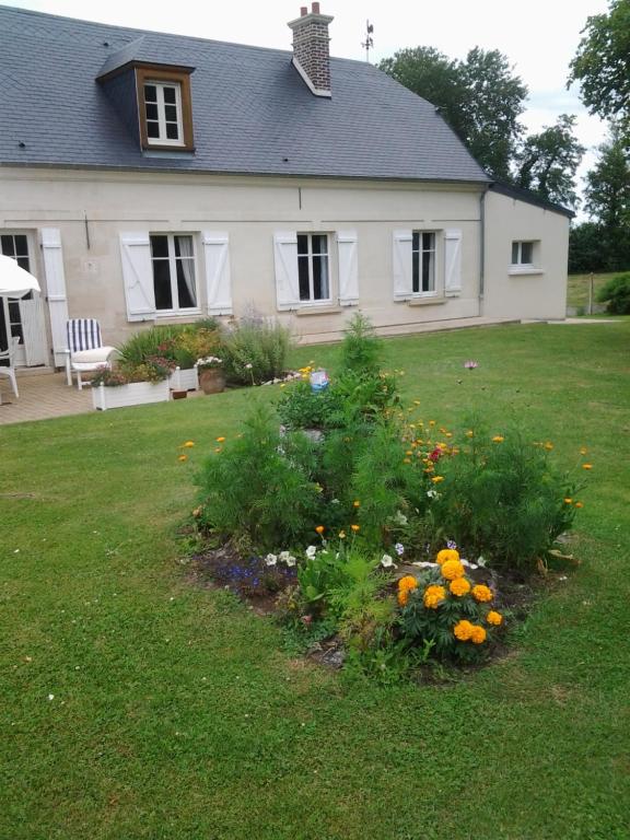 uma casa com um jardim com flores no quintal em Le Moulin em Pontoise-lès-Noyon