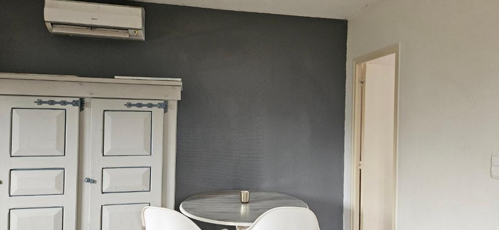 a dining room with a table and white chairs at Studio plainpied in Saint-Doulchard