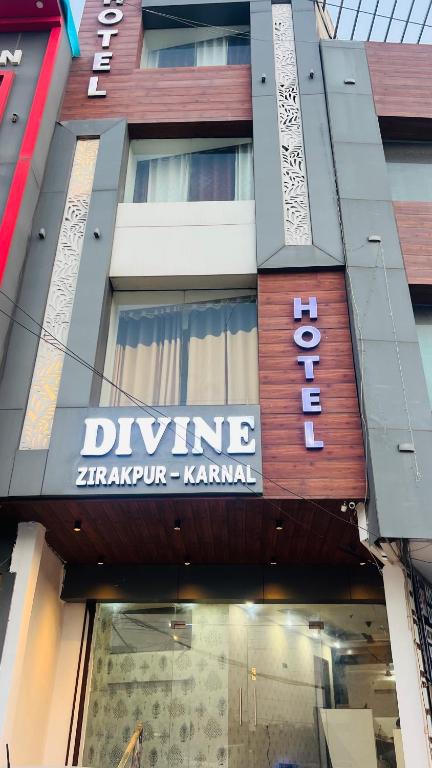 a building with a sign on the front of it at Divine Hotel in Zirakpur