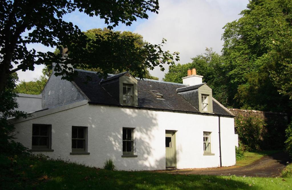 a white house with a black roof at Dunvegan Castle Rose Valley Cottage in Dunvegan
