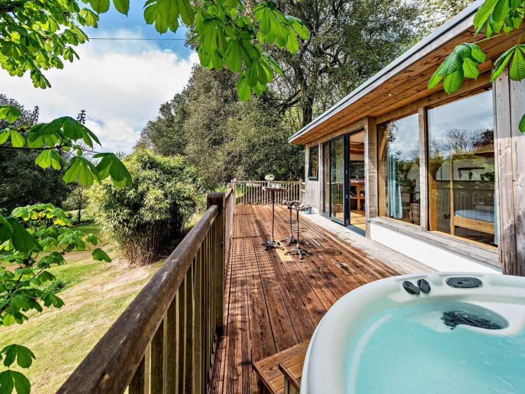 eine Badewanne auf einem Holzdeck neben einem Haus in der Unterkunft Bydown Lodge - Swimbridge Devon in Swimbridge