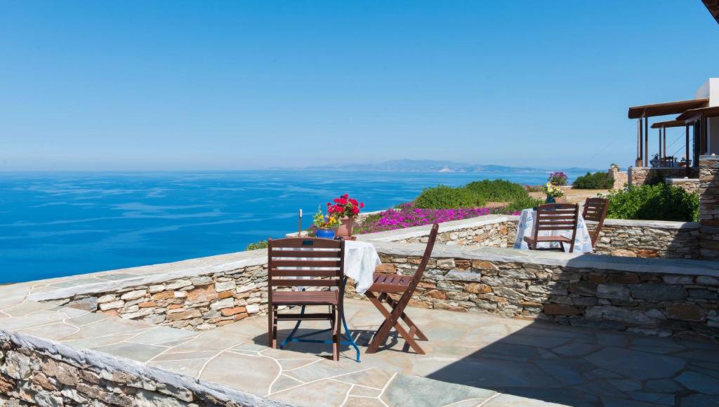 Ein Tisch und Stühle stehen auf einer Steinmauer. in der Unterkunft Spitha Sifnos in Artemonas