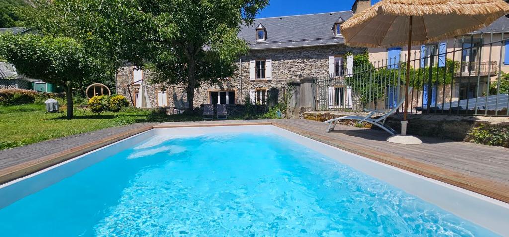 a swimming pool in front of a house at Les Échappées Belles - Gîtes et chambres d'hôtes 4 étoiles in Antignac