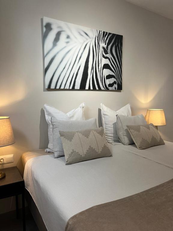 a bed with a picture of a zebra on the wall at Carmen Rooms -- Boutique B&B by the sea in Nerja
