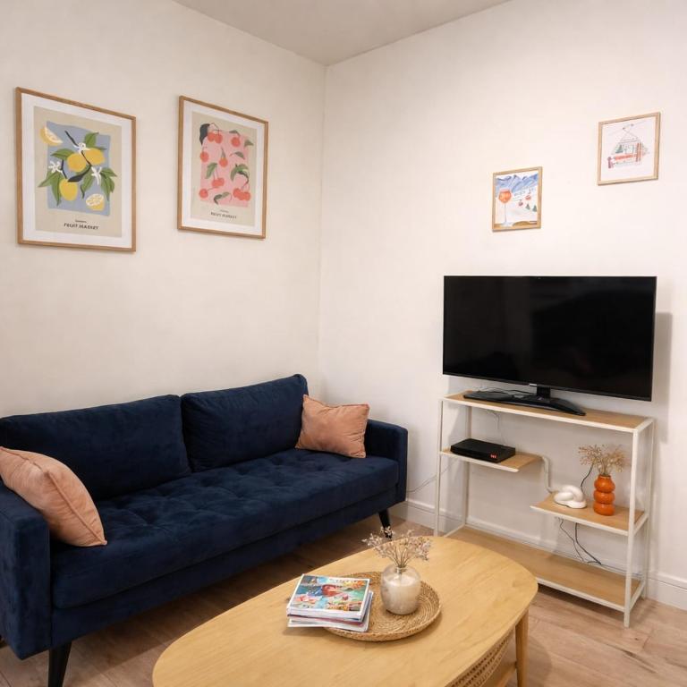 a living room with a blue couch and a table at Instant Angers Hyper Centre in Angers