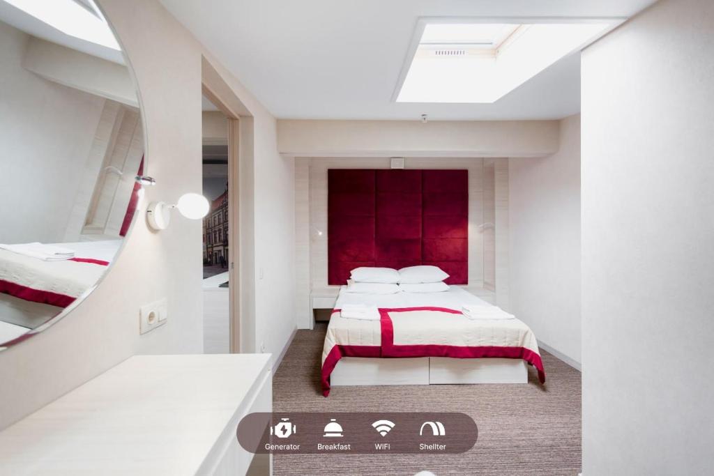 a bedroom with a bed with a red headboard and a mirror at Hotel Natalia 18 in Lviv