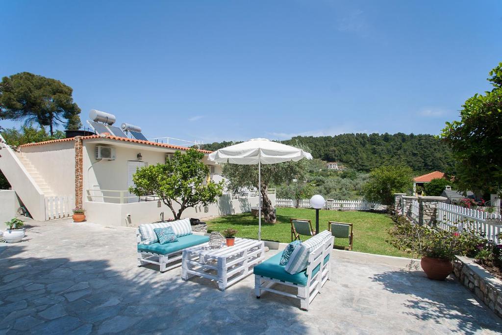 a patio with two chairs and an umbrella at Alexia Studios in Kolios