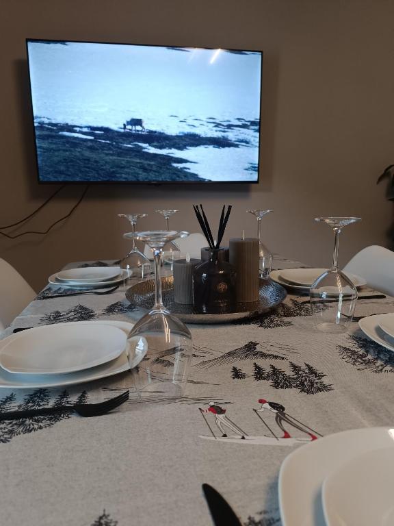 a table with white plates and a television on a wall at Alexander Lodge in Isolaccia