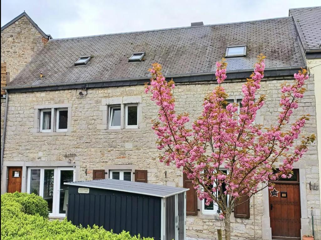 a house with a black shed in front of a tree at Le chant des sirènes in Mettet