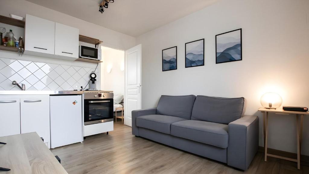 a living room with a couch and a kitchen at T2 Calme proche de la citadelle in Arras