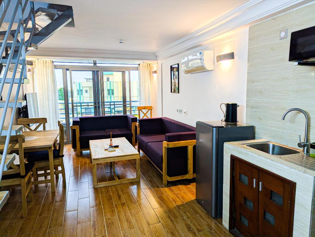a kitchen and living room with a couch and a table at Résidence Houé in Cotonou
