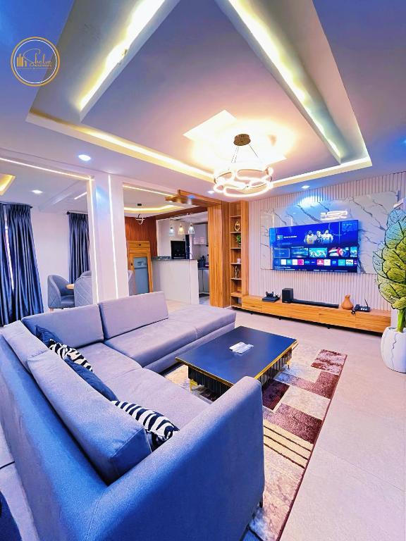 a living room with a blue couch and a table at Shelve Apartments in Aja