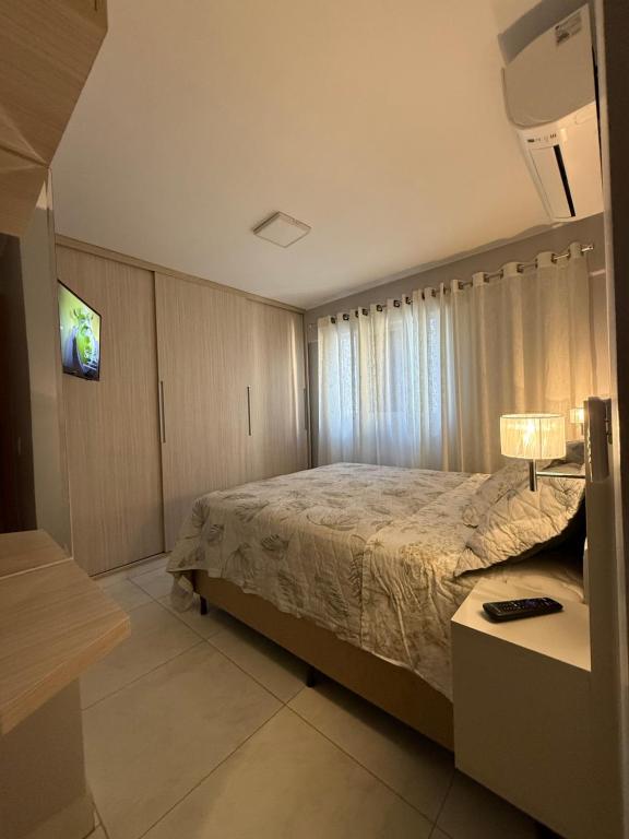 a bedroom with a bed and a television in it at Lindo Apartamento in Brasília