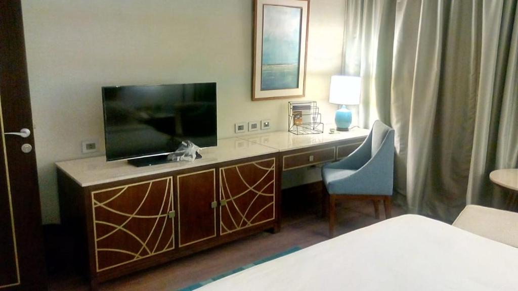 a hotel room with a desk with a television and a bed at Sharm Dreams timeshare in Sharm El Sheikh