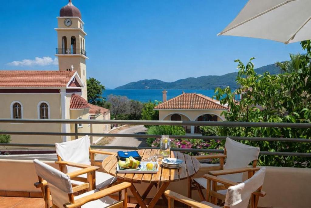 a balcony with a table and chairs and a clock tower at Iason in Karavomylos