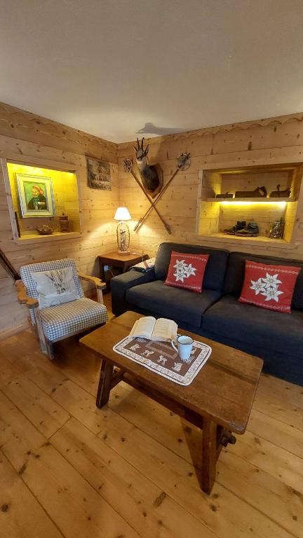 a living room with a blue couch and a table at Maison Glarey Courmayeur CIR VdA 0023 in Courmayeur