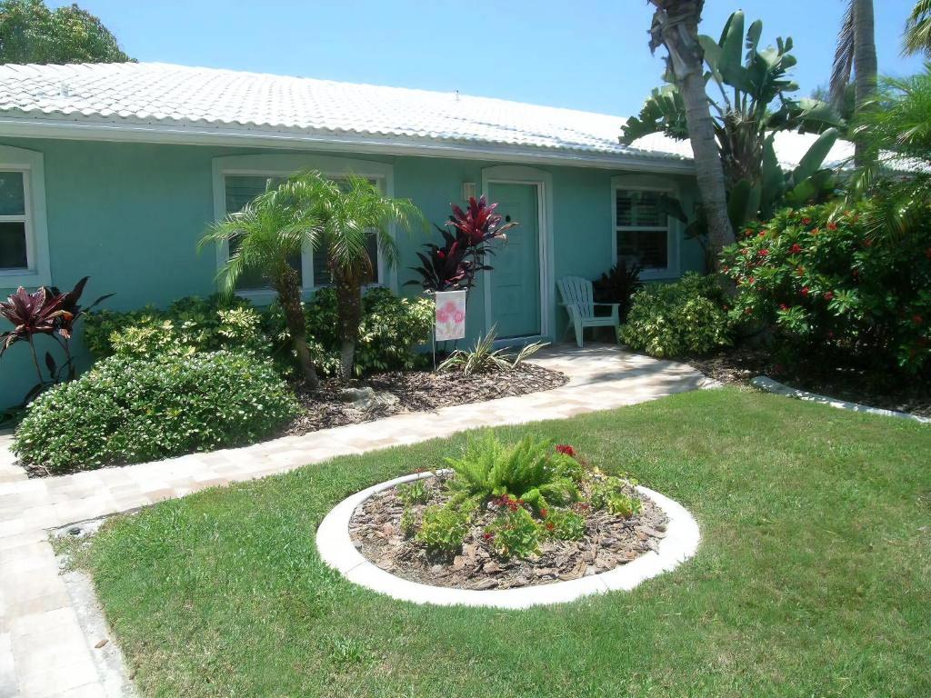 a house with a garden in the front yard at Sand Dollar Beach Side Villa in Holmes Beach