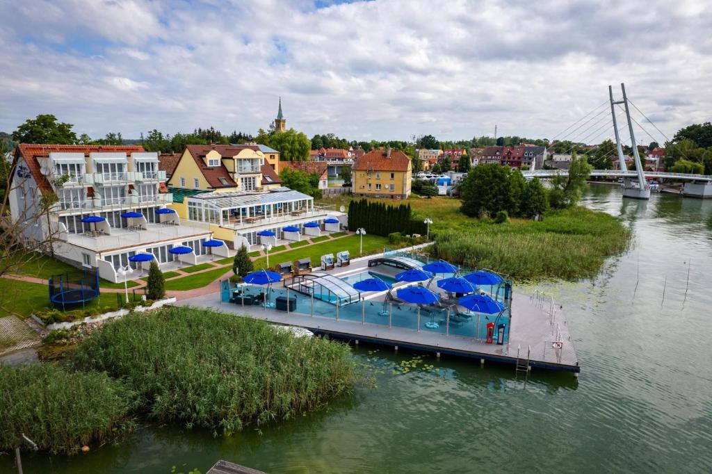 a boat with blue umbrellas on a river at Villa LeLux in Mikołajki