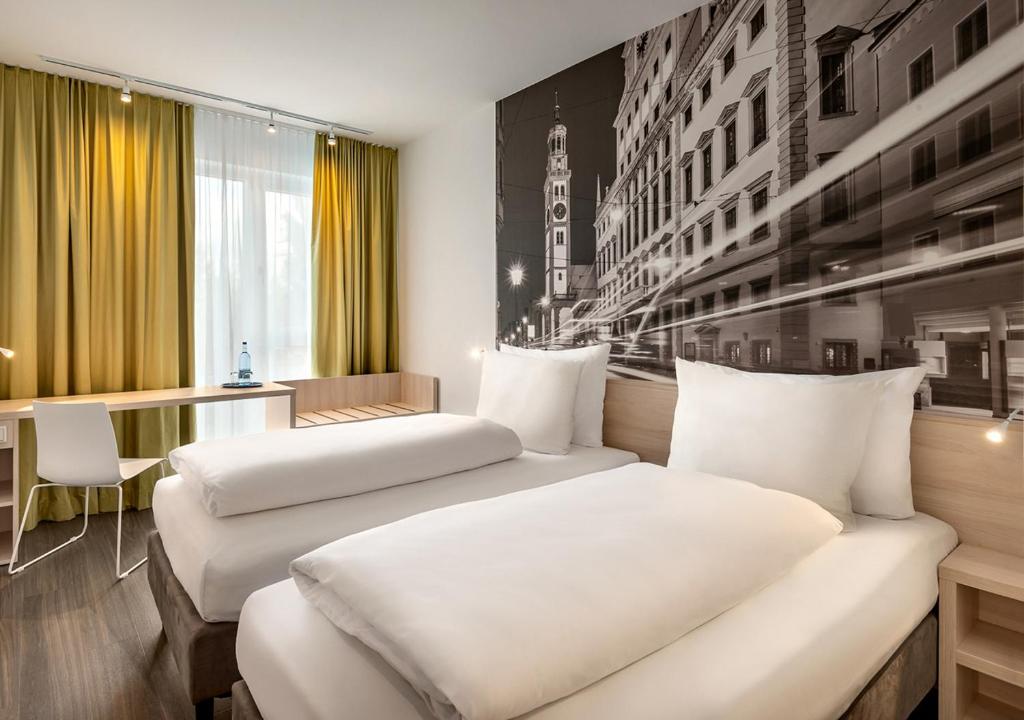 a hotel room with two beds and a desk at Super 8 by Wyndham Augsburg in Augsburg